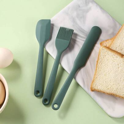 3 件套硅胶刮刀，包括一把硅胶刮刀、一把硅胶偏置刮刀和一把硅胶涂抹刷。这些是耐热和不粘的烘焙工具，适合在厨房中搅拌蛋糕和其他厨房用品