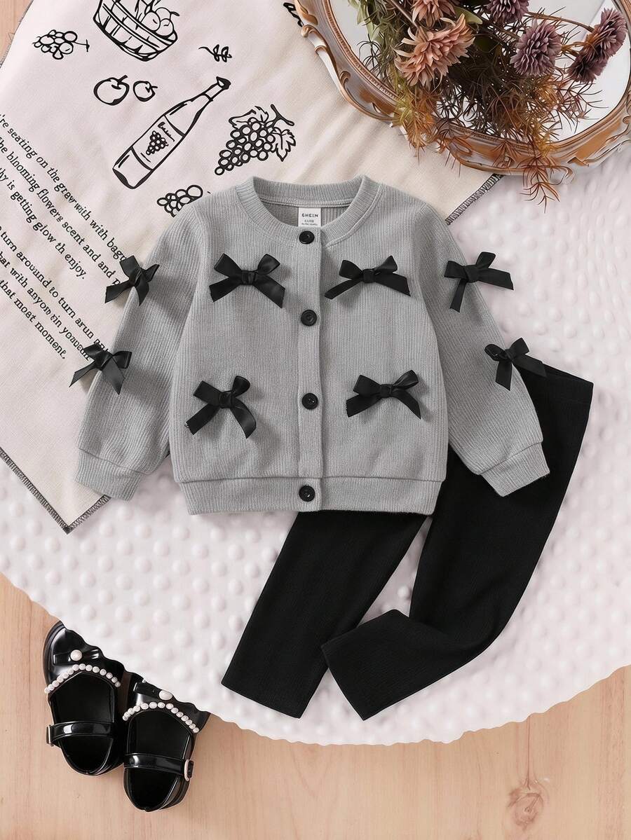 SHEIN Playful Pals 两件套韩版灰色蝴蝶结装饰开衫，适合幼儿的长袖外套。这款外套正面中央纽扣开合，方便穿着，蝴蝶结装饰更添时尚优雅气息。搭配修身黑色长裤，适合外出、旅行和日常穿着。 - 灰色 - 查看 1