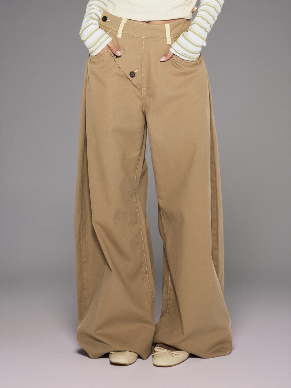 Pantaloni larghi a gamba palloncino con bottoni asimmetrici frontali, vestibilità morbida, colore kaki, stile coolgirl casual e quotidiano