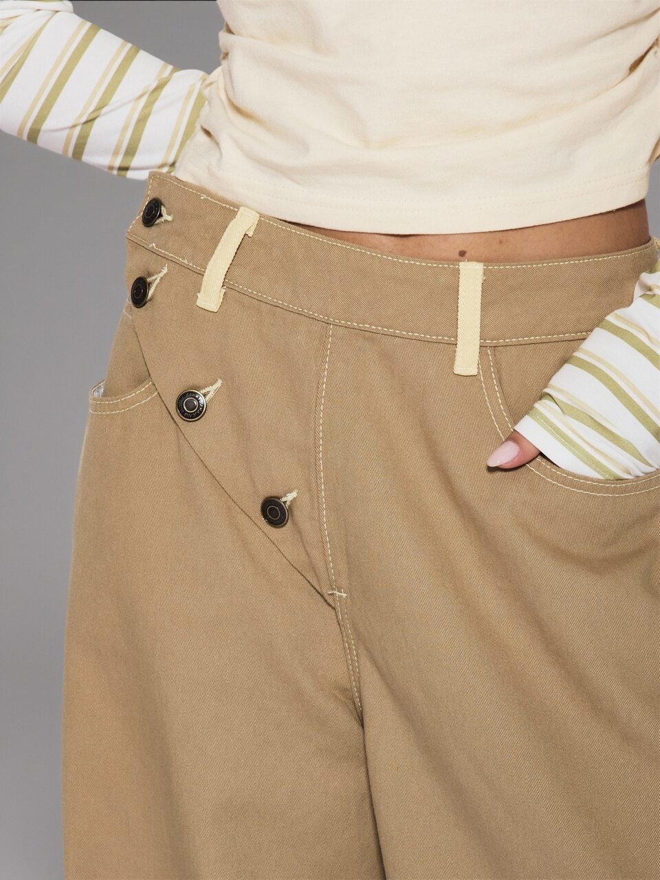 Pantaloni larghi a gamba palloncino con bottoni asimmetrici frontali, vestibilità morbida, colore kaki, stile coolgirl casual e quotidiano
