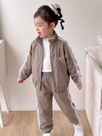 SHEIN Genkimix Kids 2pcs/Set Girls Spring/Autumn New 2025 Windbreaker Fabric Bow Embroidery Casual Fashion Heart-Shaped Woven Tape Decor Stand Collar Zipper Jacket & Casual Pants Cute Sweet Outfit