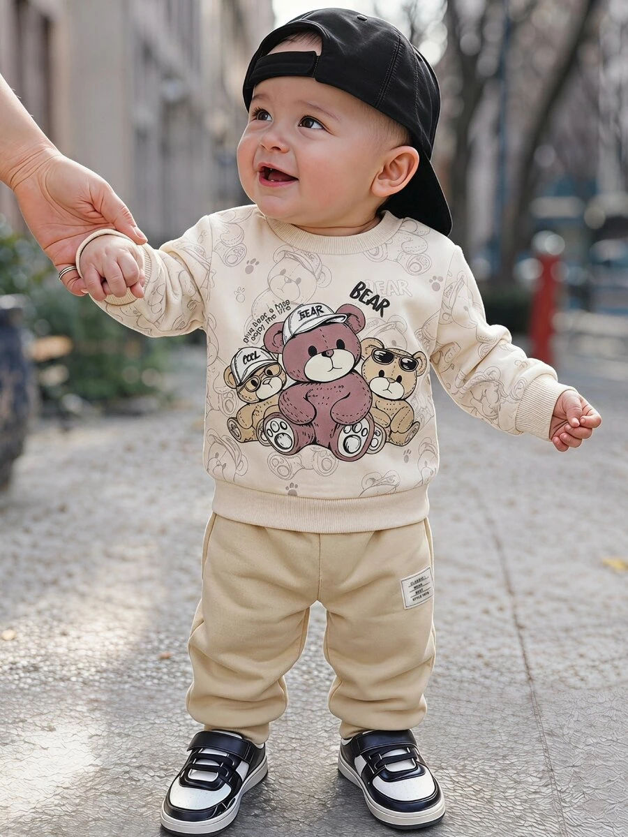 SHEIN Setelan 2 Potong untuk Bayi Laki-laki, Atasan Lengan Panjang Kerah Bulat Motif Beruang Kartun dan Celana Aprikot Polos, Cocok untuk Pakaian Olahraga, Cocok untuk Musim Semi dan Gugur - Coklat - View 1