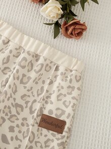 SHEIN Elladie kids (Young Girl) 豹紋 Polo 領長袖寬腿褲 2 件套，上衣為灰色豹紋搭配米白色半開 V 領設計；下身為同款豹紋寬腿長褲搭配米黃色鬆緊腰頭。適合日常上學、郊外出遊、購物、觀光、戶外拍照等場合，春秋穿搭。 - 卡其色 - 查看 5