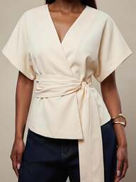 Radiana Damen-Top in großen Größen mit kurzen Ärmeln, goldfarbenen Hardware-Akzenten, asymmetrischem V-Ausschnitt und High-Low-Saum, figurbetonntes Design, geeignet für Brunch, Brautparty und andere Anlässe, weiße Damenbekleidung, zeigt einzigartigen Charme