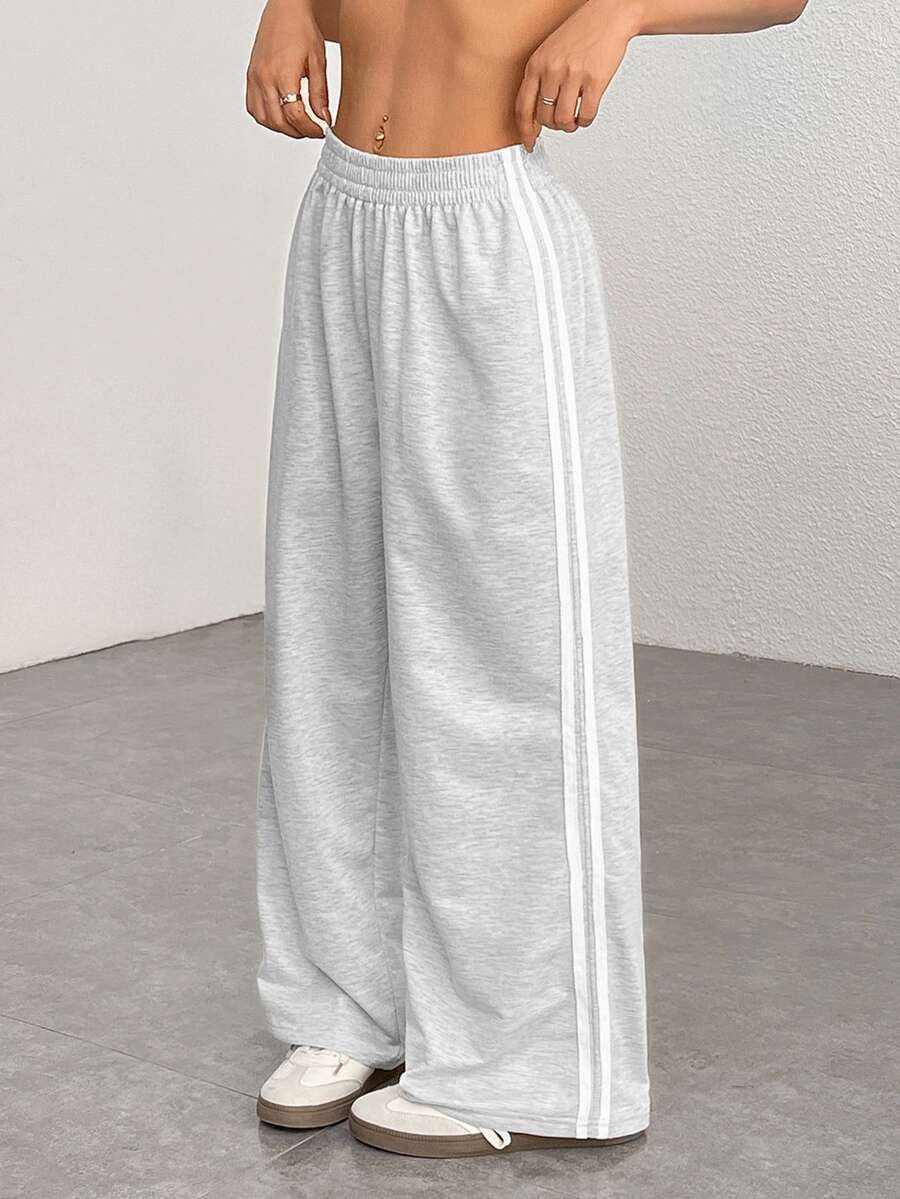 SHEIN EZwear 大码女式休闲黑色侧条纹裤,简约时尚,适合日常休闲穿着、毕业季、返校季、毕业典礼、女教师着装等场合。这款阔腿运动裤舒适宽松,版型宽松,适合各种场合。 - 淺灰色 - 查看 1