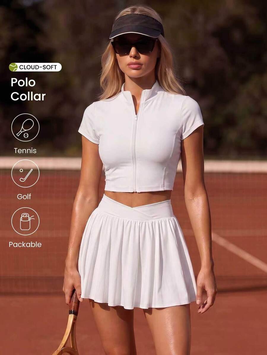 CourtClass CourtClass طقم رياضي نسائي للتنس بلون موحد، ملابس علوية بأكمام قصيرة وياقة واقفة وسحاب، مع تنورة قصيرة مطوية بخصر متقاطع - أبيض - مشاهدة 1