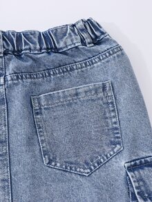 SHEIN Genkimix Kids 女童牛仔裙，淺藍色水洗牛仔，A字版型，不對稱高腰設計配彈性腰帶與金屬鈕扣，後中開衩設計，兩側3D工裝口袋，適合春秋日常通勤或休閒外出，可搭配白色T恤+短靴打造清爽造型，搭配樂福鞋展現知性氣質，實用風格，百搭配色 - 淺色水洗藍 - 查看 8