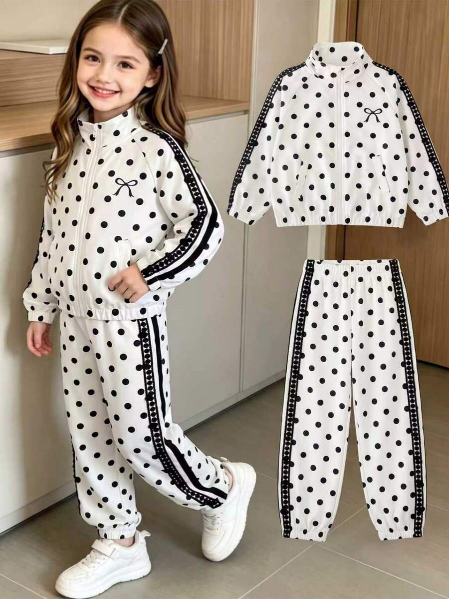 SHEIN Elladie kids 女童波點兩件套，白色底色配黑色波點印花，拉鍊開襟外套左側飾有黑色蝴蝶結印花，長褲配同款波點印花與鬆緊收口褲腳，袖口與褲腿飾有織帶飾邊，適合日常上學、社區散步、戶外出遊、購物與旅行