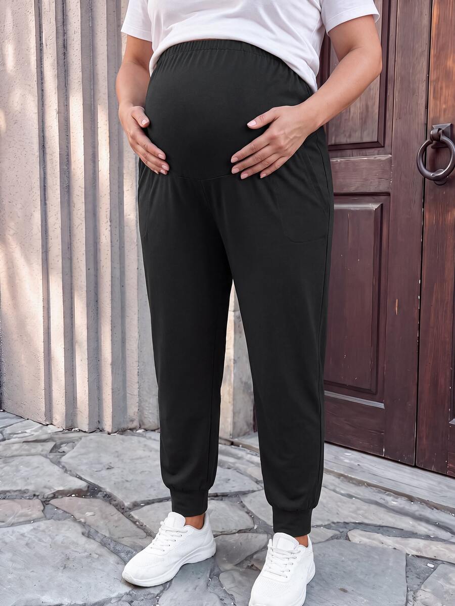 SHEIN Plus Size Maternity Comfortable Home & Sports Adjustable Elastic Waistband Belly Support Tapered Leg Knit Pants With Pockets, Black - Black - View 1