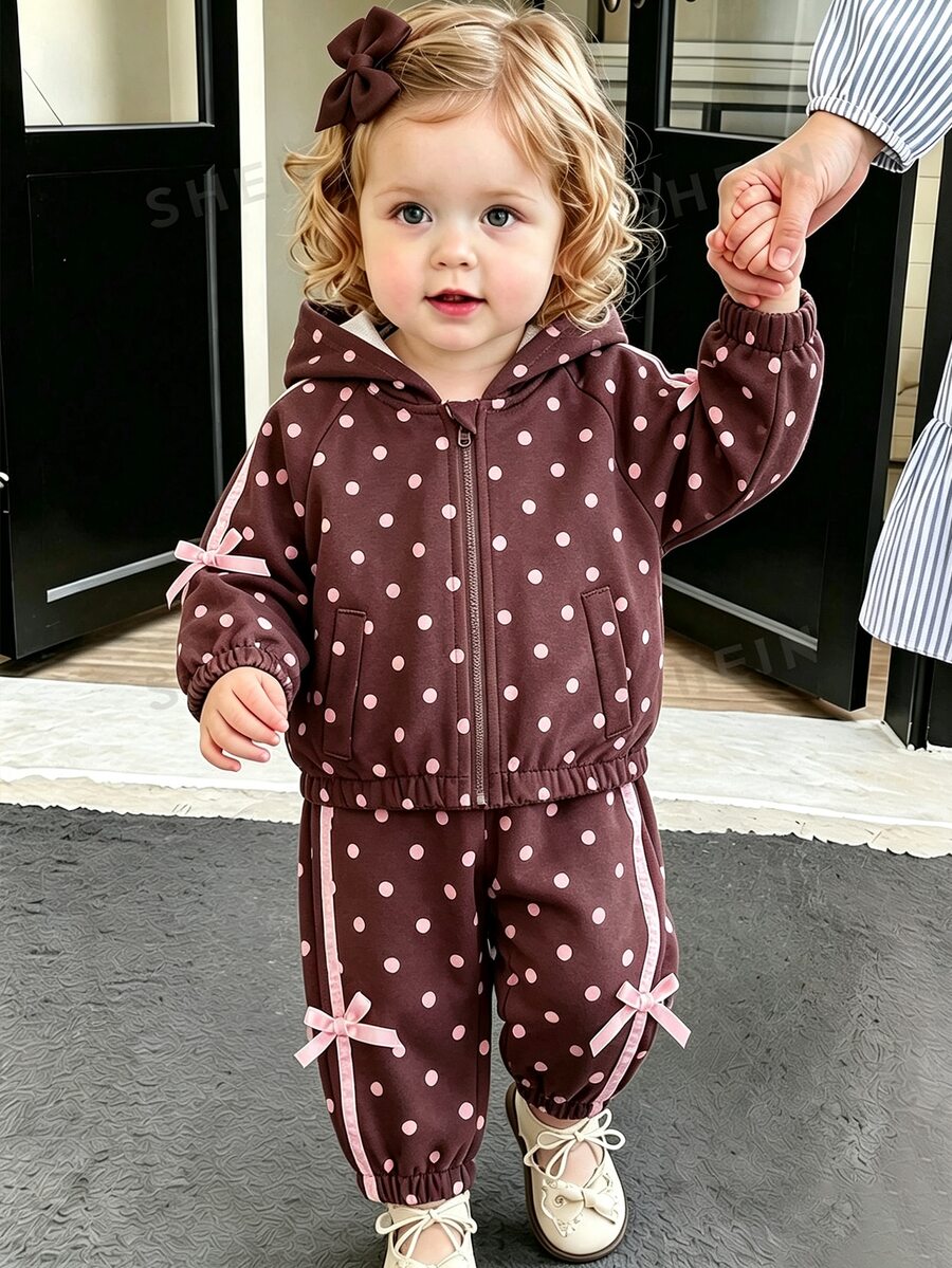 SHEIN Setelan Olahraga Dua Potong untuk Anak Perempuan Warna Cokelat dengan Polkadot Merah Muda. Jaket Berkerudung dengan Resleting Penuh dan Celana Jogger dengan Manset yang Dihiasi Pita dan Busur Merah Muda.