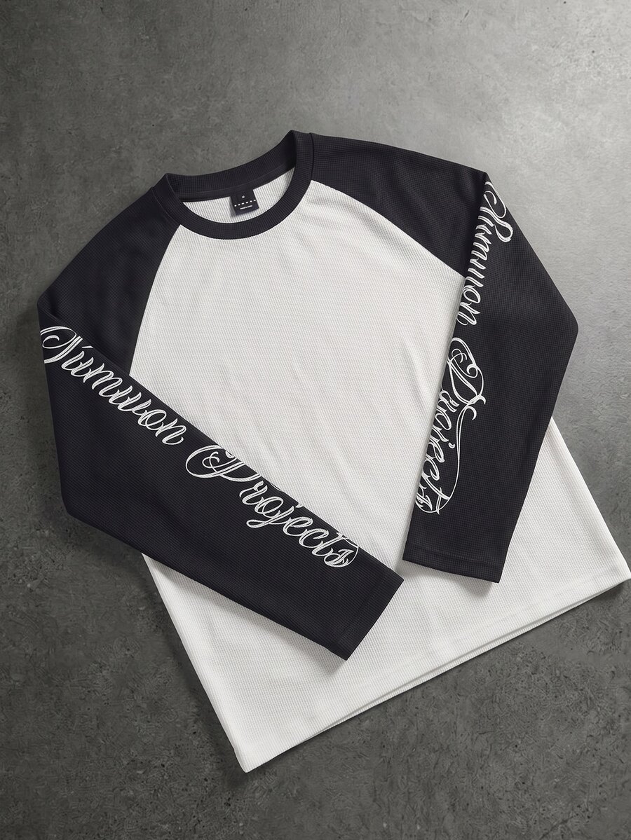 SUMWON Camiseta de manga larga raglán Common Projects con estampado de logotipo de guion en la manga, cuello redondo, top de bloques de color, esencial de otoño e invierno - Blanco y Negro - Ver 1