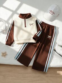 SHEIN Playful Pals 女童秋冬新款抓絨內裡運動衫套裝，半拉鍊立領運動衫，奶油色與深棕色，胸前棕色蝴蝶結印花，袖側淺藍色條紋織帶，搭配深棕色寬腿運動長褲，正面白色蝴蝶結印花與藍色條紋，韓系復古風，適合日常穿著、上學與外出 - 彩色 - 查看 3