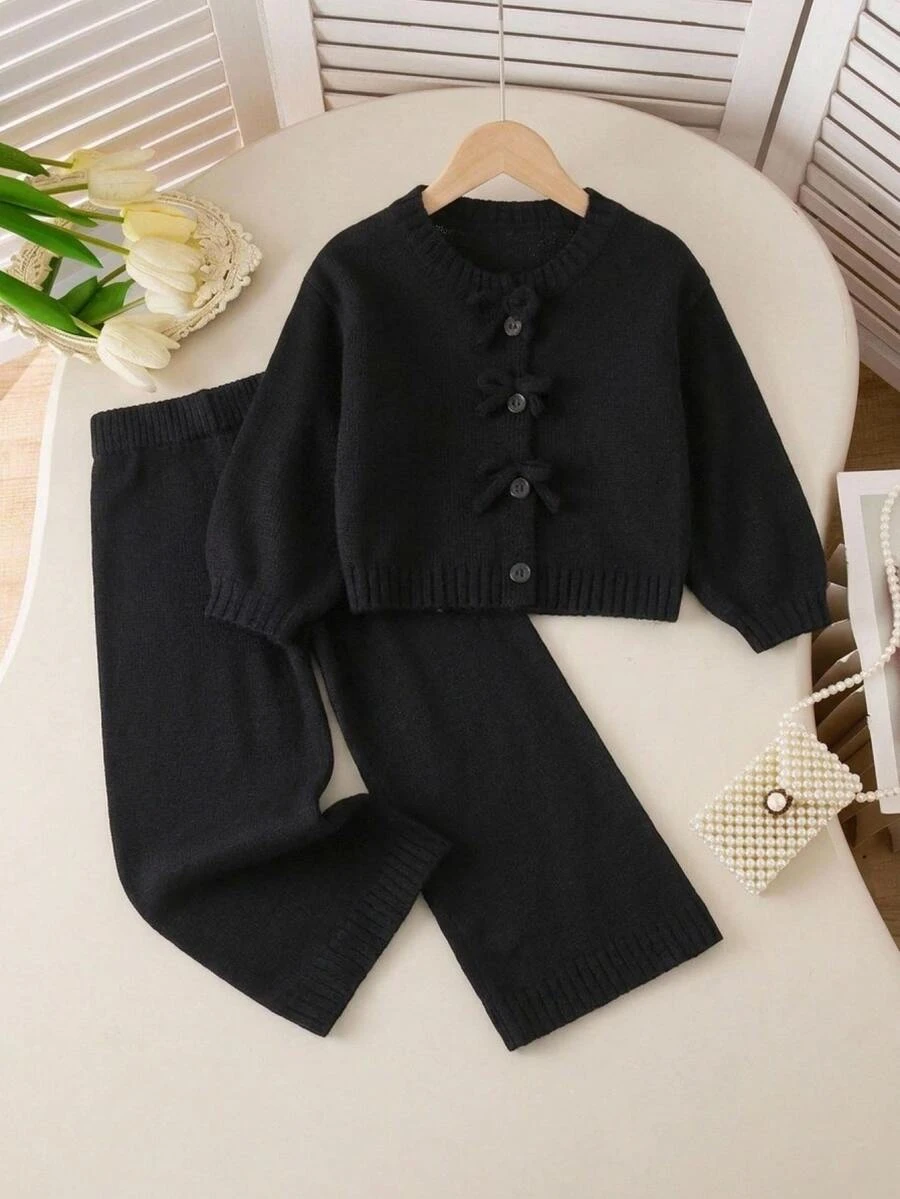 SHEIN 2件組女童幼兒針織套裝,極簡圓領黑色開襟設計搭配3D蝴蝶結裝飾,落肩長袖針織開襟衫配同款直筒針織長褲,柔軟舒適休閒可愛風,適中厚度,整齊下擺與緊口袖口,細緻質感,經典百搭,適合日常休閒穿著、上學、外出與旅行,秋冬套裝 - 黑色 - 查看 1