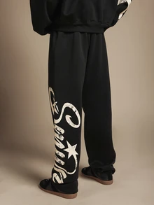 SUMWON Pantalon de jogging en molleton noir à jambes larges avec imprimé logo graffiti surdimensionné sur la jambe, motif étoile et design script crème usé - Noir - Voir 2