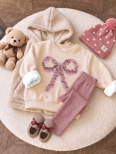 SHEIN LMoss Kids مجموعة من قطعتين للبنات الصغيرات: سويتشيرت كاجوال ناعم ومريح بقصة فضفاضة وياقة دائرية مع نمط فيونكة بحافة موجية ثلاثية الأبعاد، وسروال ليقنز سميك بنقاط بولكا، مبطن بالفليس، مناسب للخريف والشتاء، للاستخدام اليومي والمدرسة والخروجات، بأسلوب أنثوي، لعيد الميلاد وموسم الخريف
