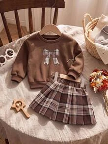 SHEIN طقم ملابس للبنات الرضع من الصوف الناعم السميك مع فيونكة زخرفية وطبعة مربعات، بلوزة سويت شيرت بياقة دائرية & تنورة خريفية مطوية بطبعة مربعات عتيقة، مناسب للشتاء - بني - مشاهدة 1