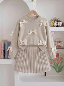 SHEIN 女童燕麥色中厚針織毛衣套裝，秋冬新款，手工重工3D歐根紗珍珠光蝴蝶結圓領落肩長袖針織上衣 + 燕麥色可愛短百褶裙，柔軟舒適面料，適合春秋單穿、冬季疊穿，適用於假期、出遊、派對、觀光、購物、休閒穿著 - 杏色 - 查看 3