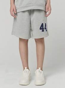 SHEIN Conjunto de camiseta con capucha de manga corta y pantalón corto suelto con estampado de letras para niñas preadolescentes. El elemento de la capucha le da un toque juguetón y enérgico a la camiseta, mientras que el estampado de letras moderno es el punto central destacado. La disposición inteligente forma palabras o frases interesantes, que muestran la personalidad y la actitud de la niña.