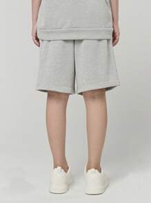 SHEIN Conjunto de camiseta con capucha de manga corta y pantalón corto suelto con estampado de letras para niñas preadolescentes. El elemento de la capucha le da un toque juguetón y enérgico a la camiseta, mientras que el estampado de letras moderno es el punto central destacado. La disposición inteligente forma palabras o frases interesantes, que muestran la personalidad y la actitud de la niña.