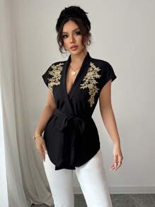 Calvaya Elegante e versatile blusa nera da donna a maniche corte con arricciatura frontale, retro lungo, con rifinizione in pizzo dorato e tessuto non elastico