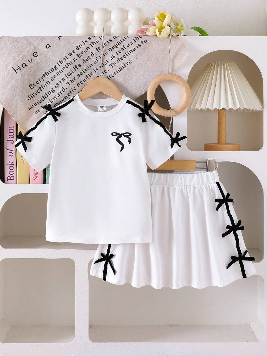 Bộ 2 món/bộ cho bé gái áo thun in nơ cổ tròn dễ thương màu đen thoải mái và váy ngắn cạp chun - trắng - Xem 1