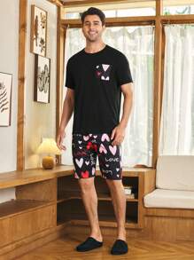 Manfinity CoupledUp Conjunto de ropa de casa informal para hombres con top de manga corta en negro con bolsillo y pantalón corto estampado de corazones