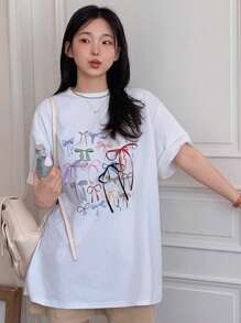 DAZY Camiseta de verano con cuello redondo, lazo impreso, camiseta oversize con estampado gráfico, camiseta casual para mujer/niña