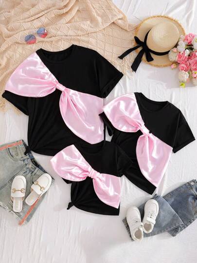 女童超大码黑色T恤，针织面料，大蝴蝶结装饰，时尚，粉色点缀，可爱休闲风格，适合春夏秋季节，搭配牛仔裤或休闲裤，适合外出聚会