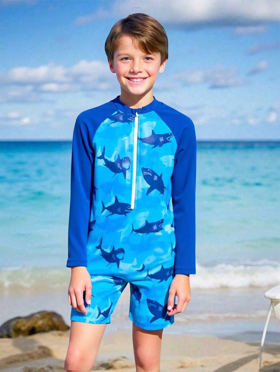 SHEIN 这款青少年男童泳衣采用鲨鱼主题设计,独特醒目。蓝色底色搭配活泼的图案,散发着无所畏惧的冒险精神。柔软舒适的材质适合各种水上活动。长袖设计有效防晒,保护儿童娇嫩的肌肤,加长拉链方便穿脱。这是一款2025年新款泳衣,适合热爱游泳的小男孩,让他们在水中更加自信。 - 彩色 - 查看 1