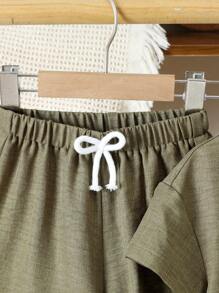 Completo con maglietta a maniche corte con bottoni sul davanti e pantaloncini per ragazzo giovane