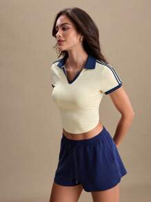Blusa deportiva tipo polo de mujer con mangas cortas y cuello de color block