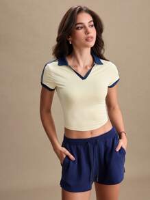 Blusa deportiva tipo polo de mujer con mangas cortas y cuello de color block