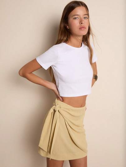 Nöista Falda corta con diseño envolvente y detalle de lazada lateral. Textura suave y ligera, perfecta para días calurosos, caminatas al aire libre, salidas informales o looks relajados pero sofisticados.