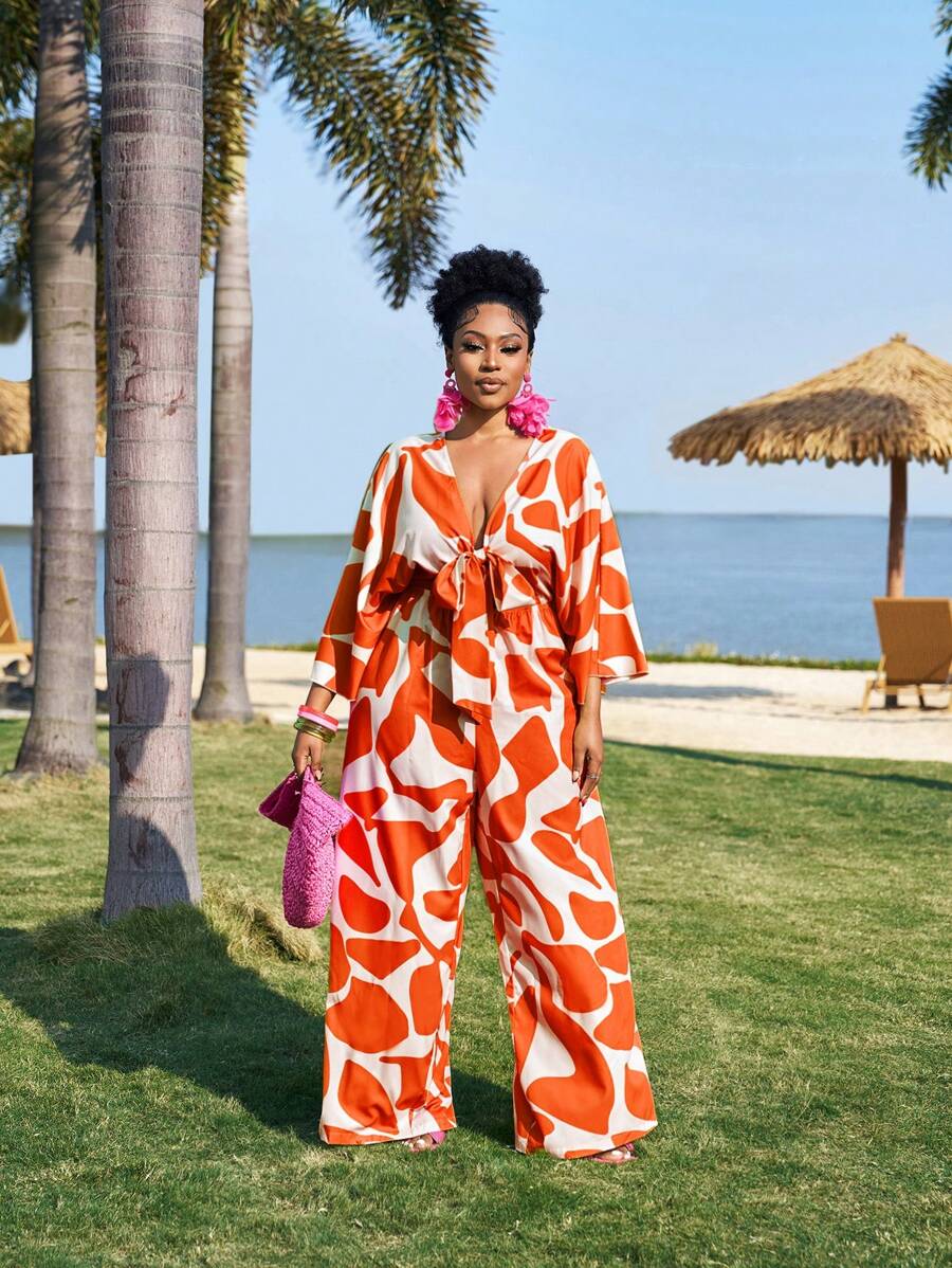 Slaydiva Elegantes romantisches Jumpsuit mit Blumenmuster und Bindedetail in Große Größen, Frühlings- und Sommerbekleidung für Frauen, formelle orangefarbene Hosen für Urlaubsoutfits von Frauen, Resort-Bekleidung