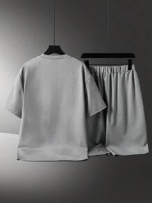 2 piezas Conjunto casual para adolescentes varones, camiseta tipo jersey con estampado en inglés de acero en relieve y diseño de cuello redondo, talla grande shorts con diseño minimalista texturizado y pierna curva, adecuado para verano y otoño