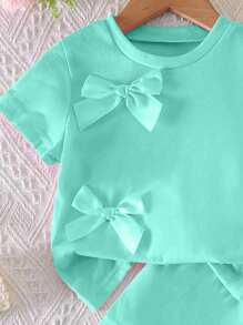 SHEIN Set de 2 piezas con top de cuello redondo de manga corta con lazo decorativo y shorts de cintura elástica para niñas jóvenes, color rosa