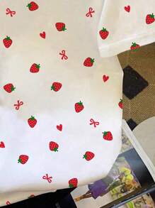 SHEIN EZwear Camiseta feminina casual minimalista com estampa gráfica de laço de morango e gola redonda, manga curta e folgada, adequada para férias, festivais de música, viagens de meninas