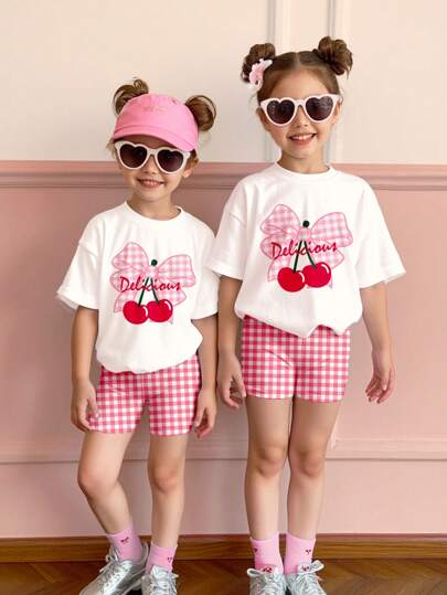 SHEIN Set de 2 piezas para niñas jóvenes: camiseta de manga corta de cuello redondo y pantalones cortos con estampado de cuadros rosados y cerezas, informal para verano