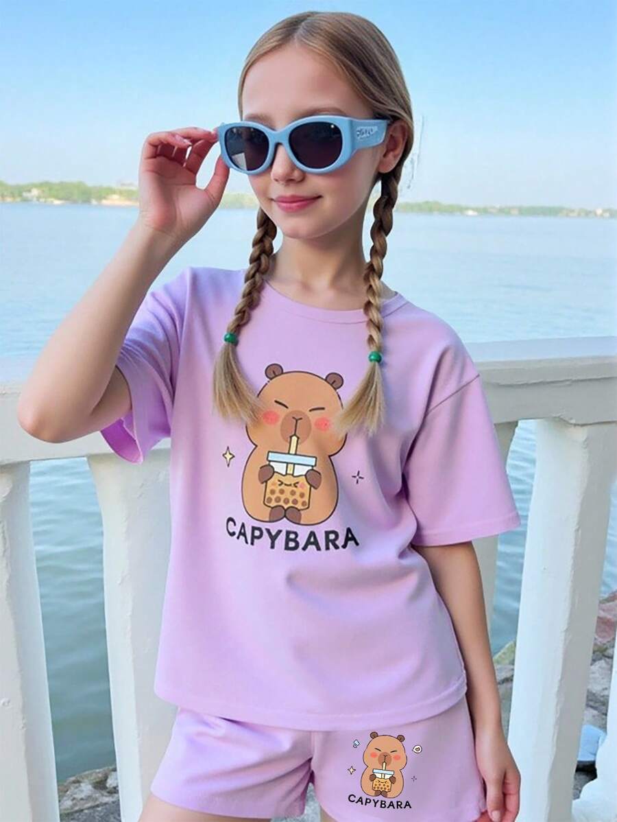SHEIN Conjunto de 2 piezas para niñas, camiseta de manga corta con cuello redondo y estampado de Capibara tomando bubble tea, y pantalones cortos, conjunto de verano casual y lindo de color morado para niños mayores - Morado - Ver 1