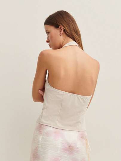 Nöista Halter Backless Top With Button Details-An Elegant Addition To Skirts Or Shorts For Polished Summer Work Outfits.