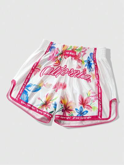 Street Life Pantalones cortos de hombre con patrones florales vibrantes, que presentan vívidos colores rosa, rojo, azul y amarillo. Acentuados por un cinturón elástico con ribete rosa, diseñados para uso deportivo casual. Los pantalones cortos presentan un gran texto "California" en color rosa en la parte delantera, junto con un texto talla grande pequeño "Free" y "Spirits" también en rosa.