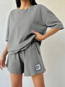 Camiseta de mujer de 100% algodón de color liso y shorts con detalles bordados