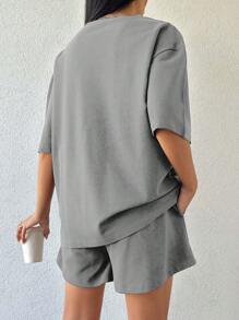 Camiseta de mujer de 100% algodón de color liso y shorts con detalles bordados