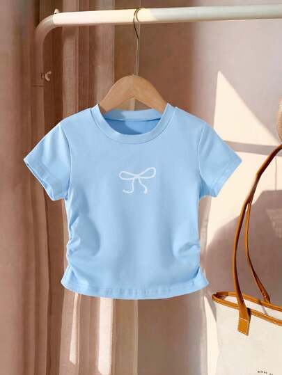 Genkimix Kids Camiseta azul de manga corta y cuello redondo con estampado de lazo para niñas jóvenes, con bajo asimétrico, top versátil de verano para vacaciones de verano de niñas jóvenes