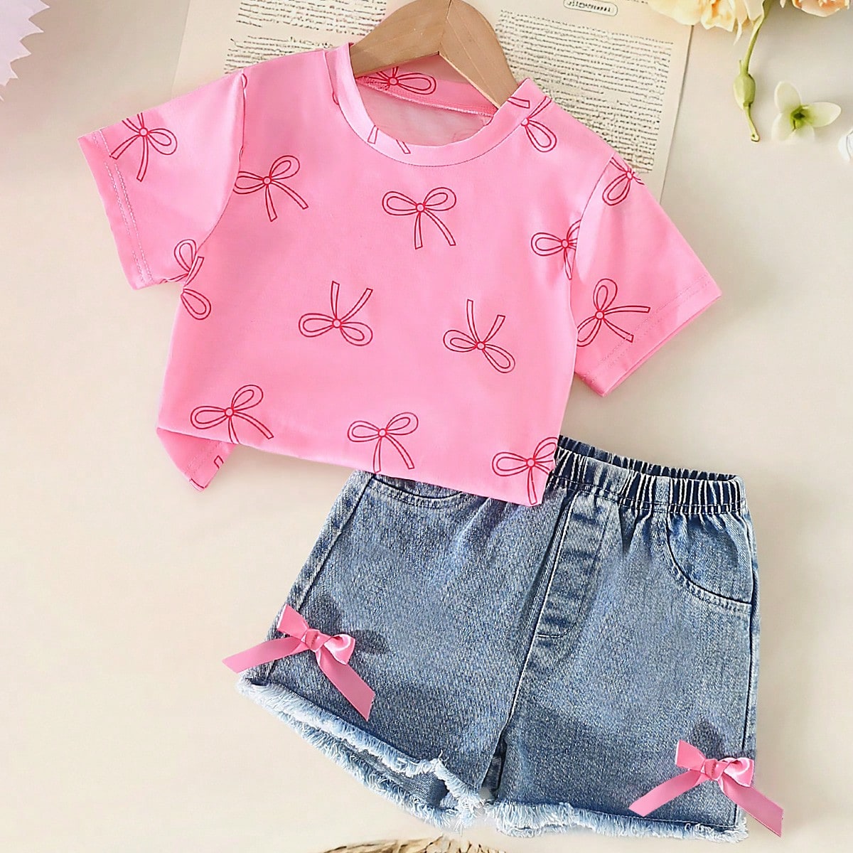 Conjunto informal de niña con blusa de manga corta con cuello redondo y estampado de moño, y shorts vaqueros con cintura elástica y moño
