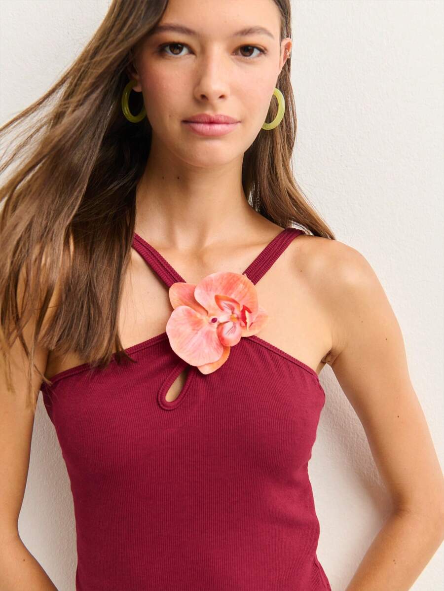 Nöista Ribbed Tank Top Features A Strap Design, A Teardrop Keyhole Cutout, And A Statement Orchid Embellishment. Stylish And Form-Fitting, It's Perfect For Summer Dates, Concerts, Or Adding Flair To Casual Looks.