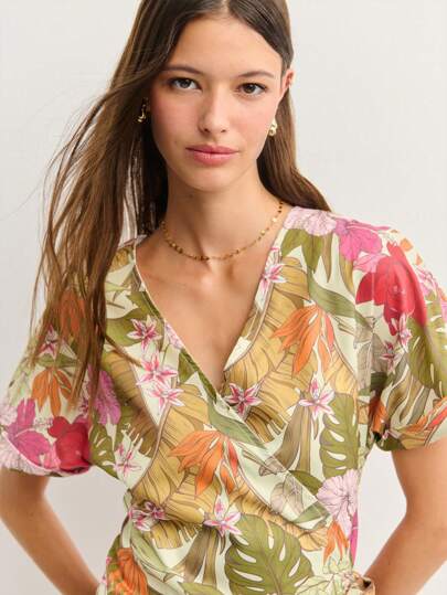 Nöista 迷你裹身裙，以柔和的橄榄色调为底，饰有鲜艳的热带花卉印花。搭配迷人的V领和侧系带，是海滩度假、花园派对或休闲夏日的完美之选。7月4日