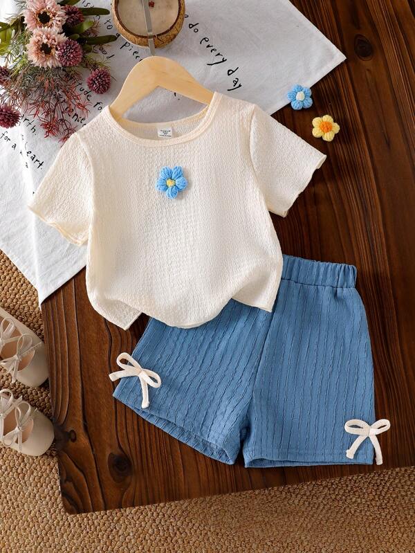 Conjunto de camiseta de textura floral tejida en color albaricoque y shorts con lazo azul para niñas, un conjunto de vestir cómodo y suave de manga corta para el verano