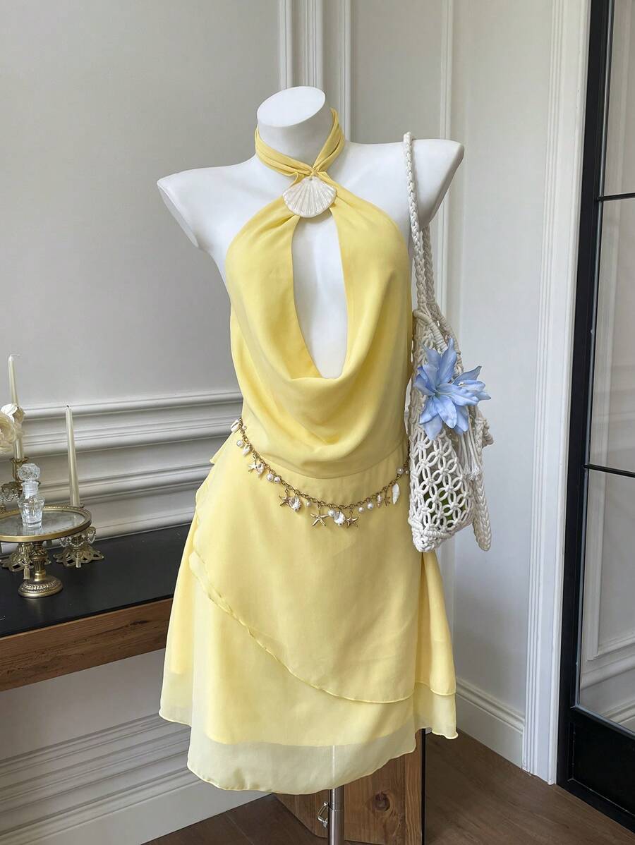 SHEIN EZwear Vestido mini nuevo y sexy con espalda descubierta, cuello halter, decoración de concha, hebilla, escote en V profundo, volantes asimétricos en el bajo, en color crema amarillento sólido, para primavera y verano, estilo hada para mujer, vestido de playa pastel