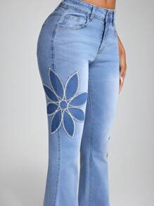 Jeanoix Jeans acampanados lavados con aplicaciones y bordados a la moda